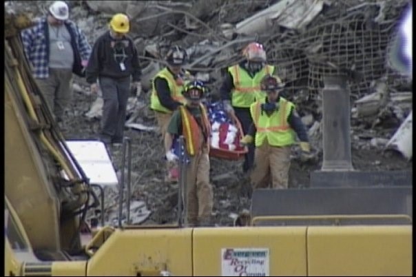 Rescue workers carry a casket covered in an American flag out of the debris after the 9/11 attacks in New York.